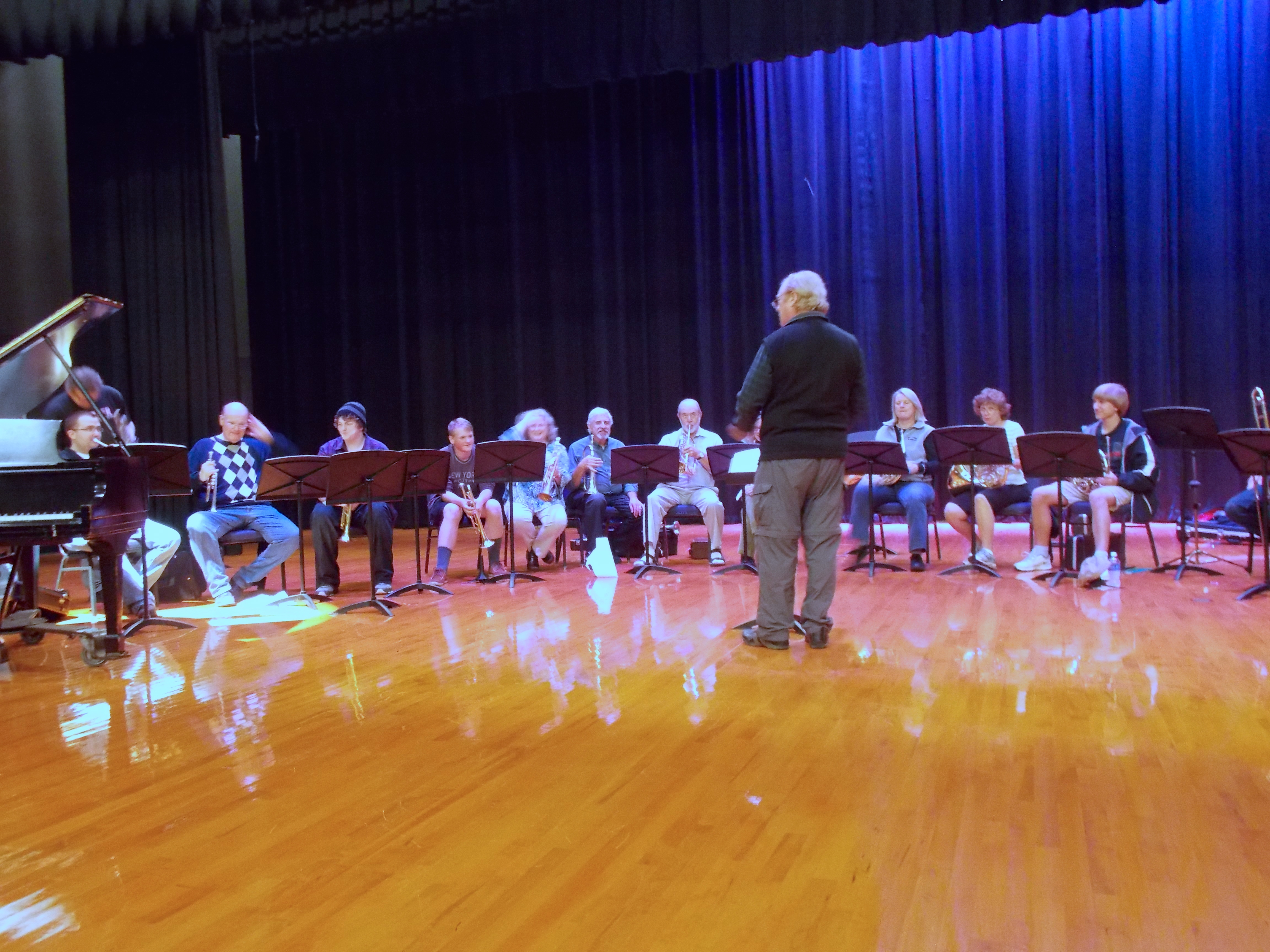 Dr. Morris is speaking to group of twelve clinic members, who are all sitting with their instruments in hand.